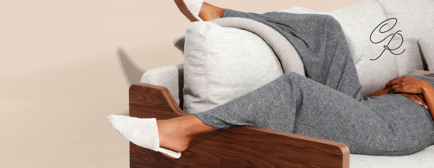 a woman's legs and feet as she lays on a bright couch